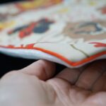 DEPLUSBELLE vous propose une housse de coussin unique en velours blanc cassé et néoprène imprimé avec passepoil orange!